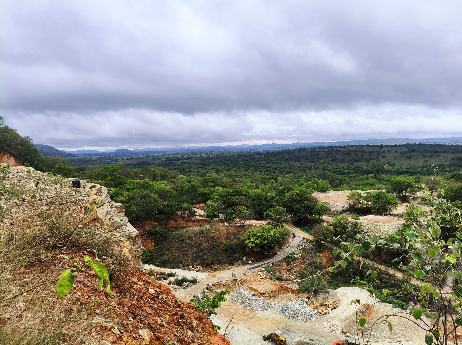 Vista do alto de uma área em levantamento, com cerrado e serras ao fundo, na região central de Minas Gerais